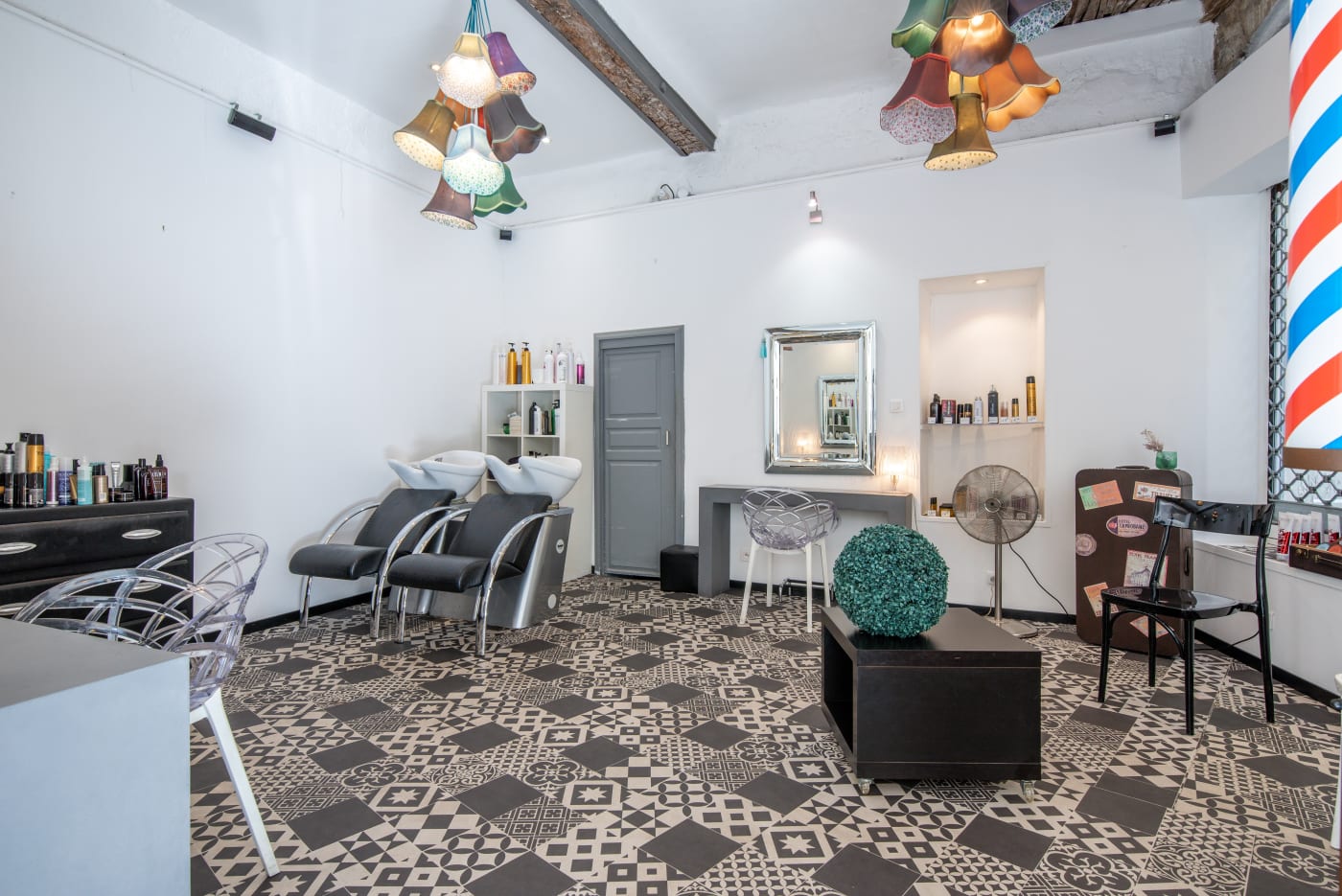 Vue d'ensemble du salon avec bacs de lavage et suspensions colorées